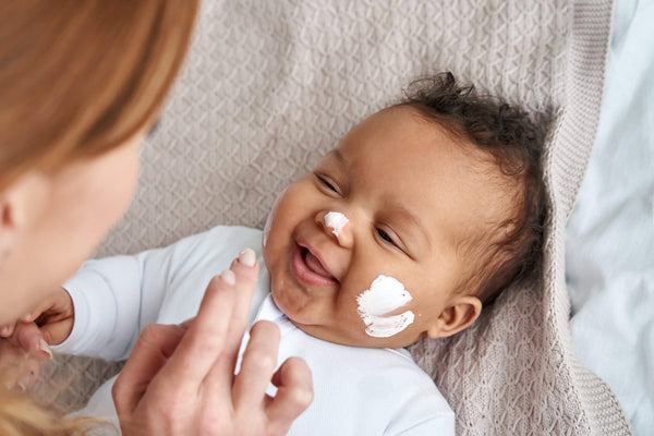 Baby with lotion on his face